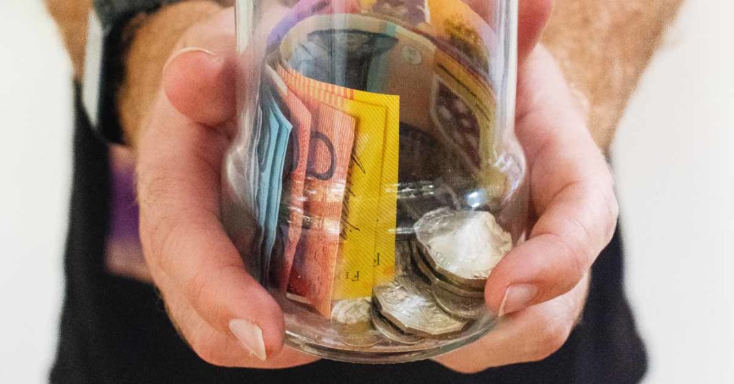australian money inside of a glass mason jar